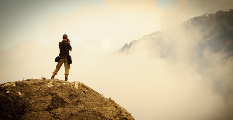 アマチュアカメラマンが山の上で写真を撮っている